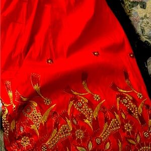 Long satin red skirt with gold design on the bottom